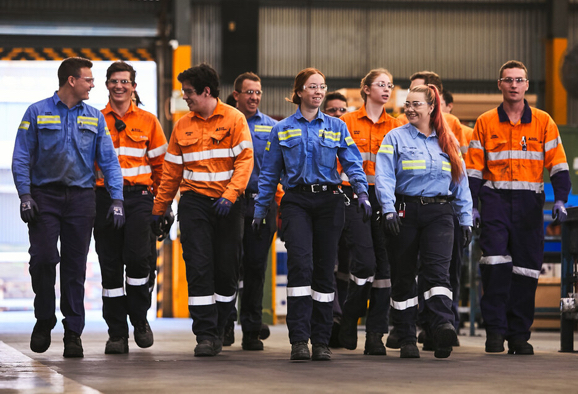 Groupe diversifié d’employés de Rio Tinto marchant dans un bâtiment industriel