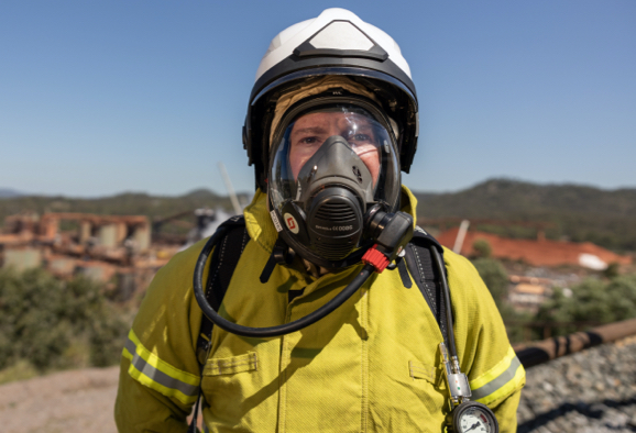 Employé de Rio Tinto portant une veste, un casque et un respirateur